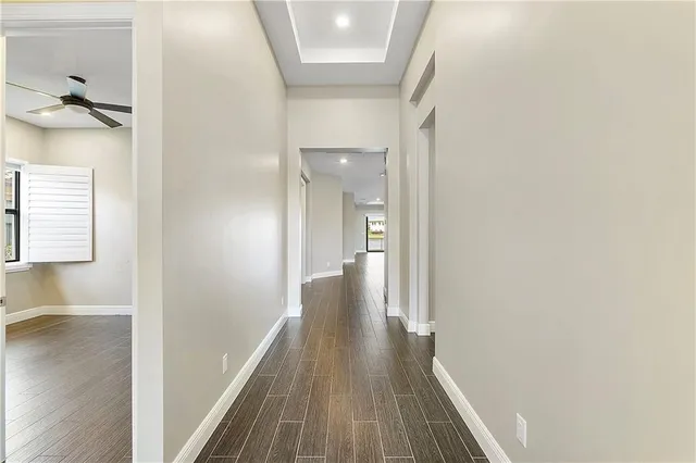 a view of a hallway with wooden floor and staircase