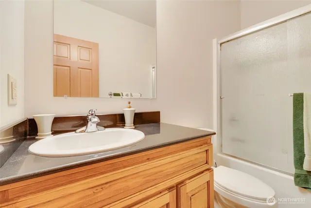 a bathroom with a granite countertop sink toilet and shower