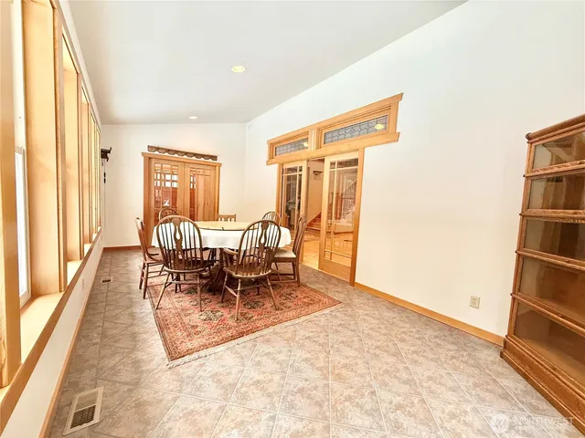 a dining room with furniture and a floor to ceiling window