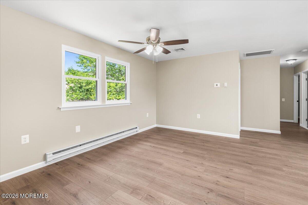 16 D Spring Street, Unit 50 Whiting, NJ 08759 - Photo 9 of 28 an empty room with wooden floor chandelier fan and windows