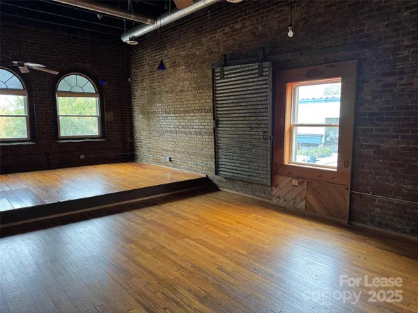 a view of a livingroom with wooden floor and window