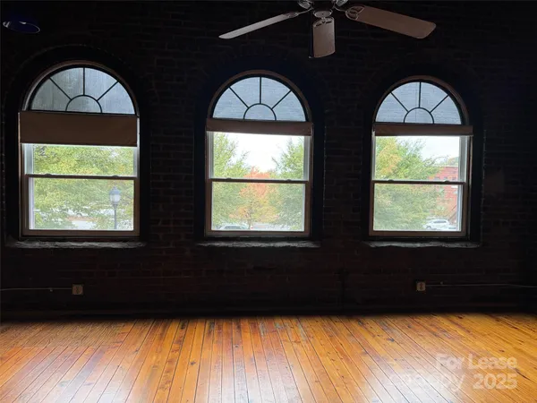 a view of wooden floor and windows in a room