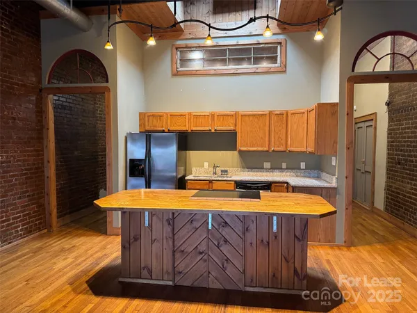 a kitchen with stainless steel appliances kitchen island granite countertop wooden cabinets a sink and dishwasher