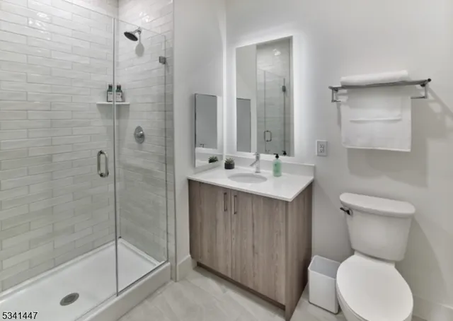 a bathroom with a shower sink mirror and toilet