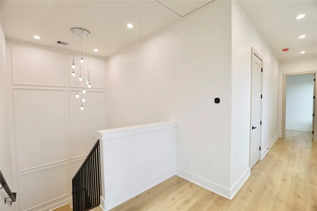 a view of a hallway with wooden floor and staircase