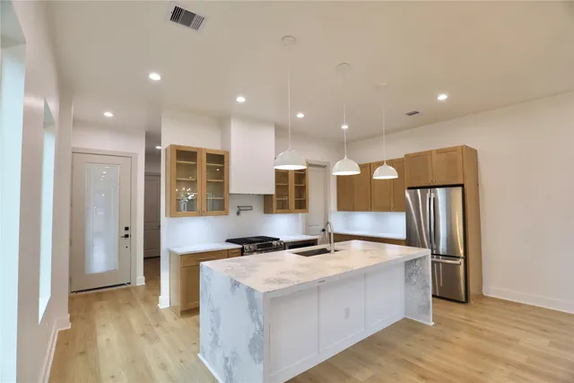 a kitchen with stainless steel appliances granite countertop a sink a stove and a refrigerator