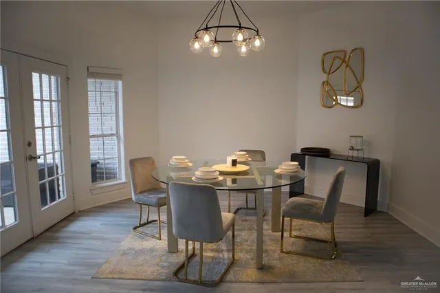 a view of a dining room with furniture a chandelier and wooden floor