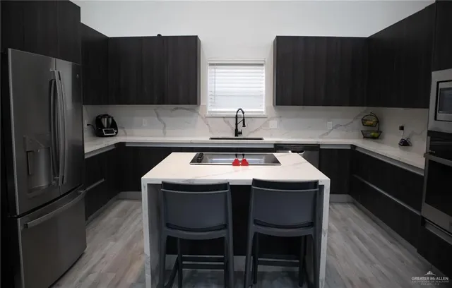 a kitchen with a sink a stove a refrigerator and cabinetry