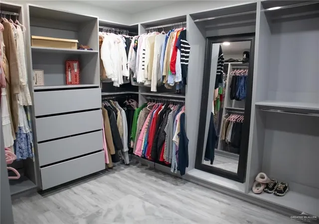 a view of walk in closet with clothes and shoes