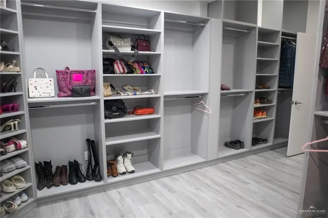 a view of walk in closet with clothes and shoes