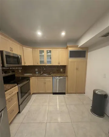 a kitchen with stainless steel appliances a stove a sink and a refrigerator