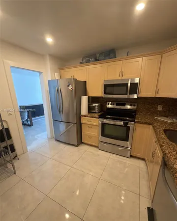 a metallic refrigerator freezer sitting in a kitchen