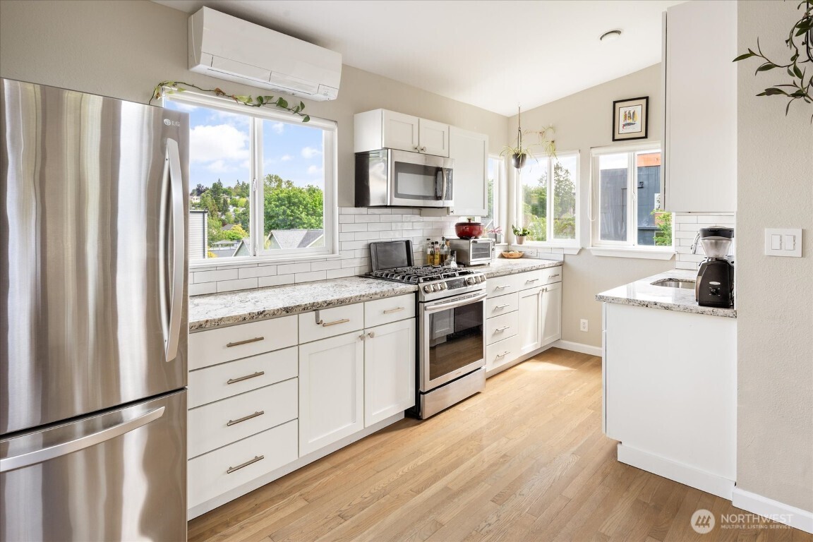 1724 26th Avenue Seattle, WA 98122 - Photo 11 of 28 a kitchen with white cabinets and appliances
