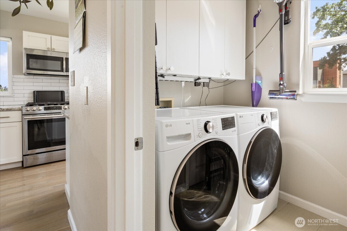 1724 26th Avenue Seattle, WA 98122 - Photo 15 of 28 a view of washer and dryer with kitchen in the background