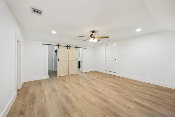 a view of an empty room with wooden floor