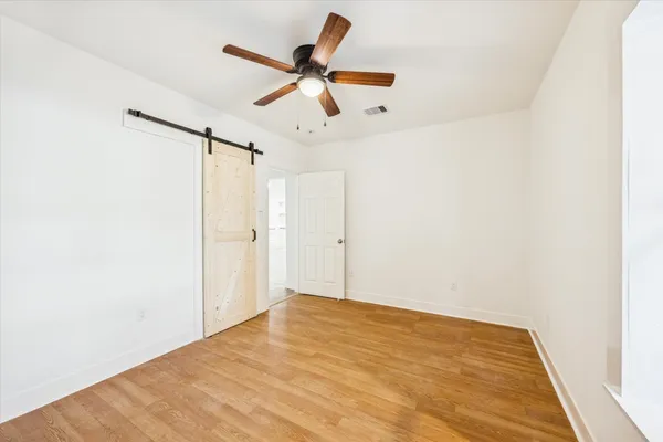 a view of a big room with wooden floor and a ceiling fan