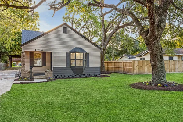 a front view of a house with a yard and tree