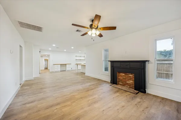 a view of an empty room with a fireplace and a window