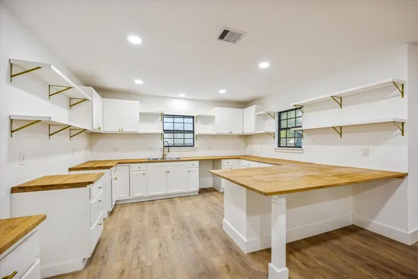 a kitchen with stainless steel appliances granite countertop a table chairs sink and cabinets