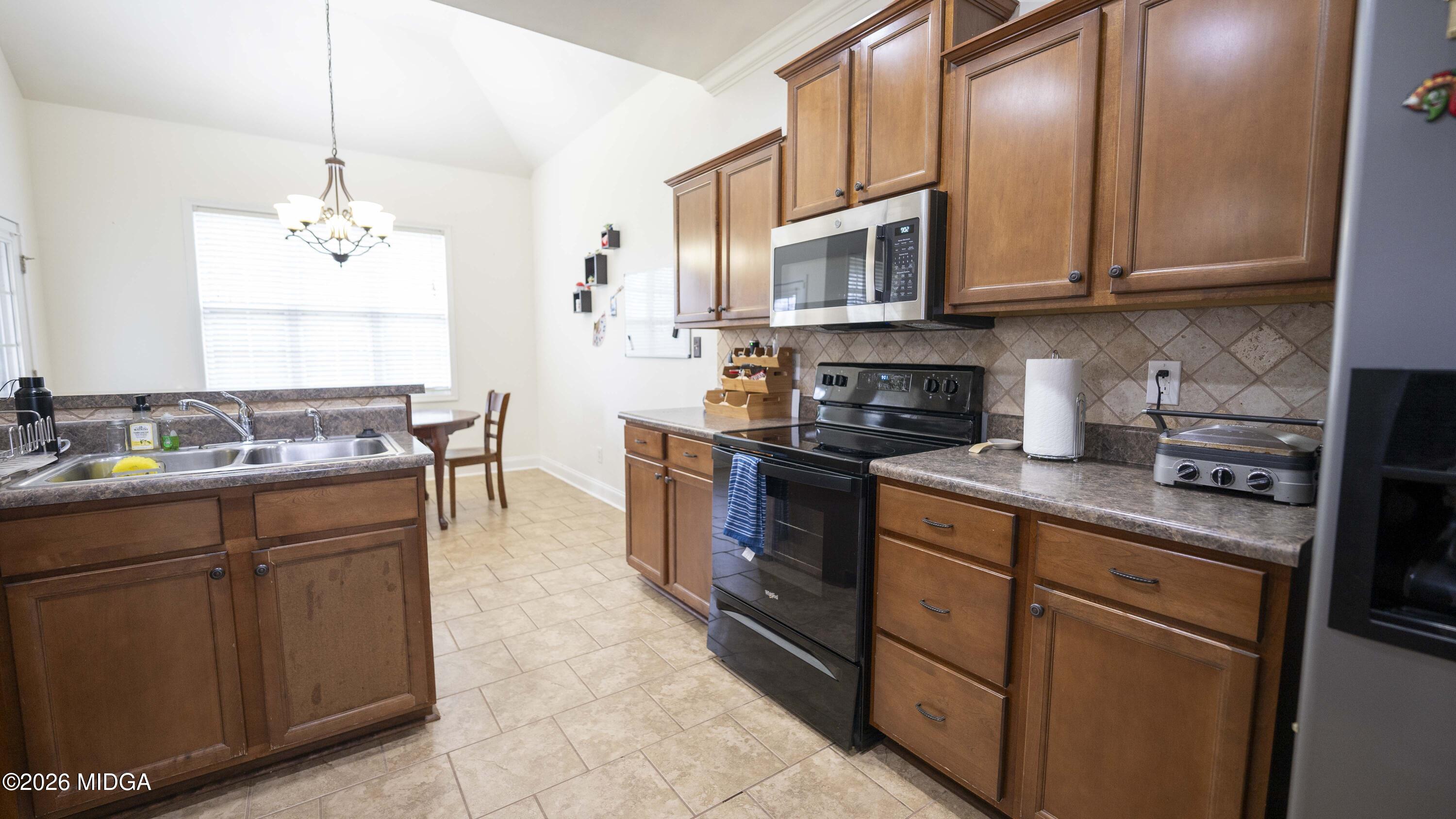 207 Broderick Circle Warner Robins, GA 31088 - Photo 15 of 33 a kitchen with stainless steel appliances granite countertop a sink stove and microwave