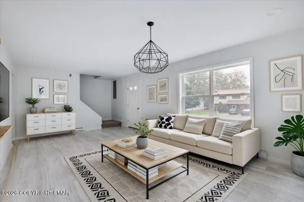 a living room with furniture a chandelier and a window