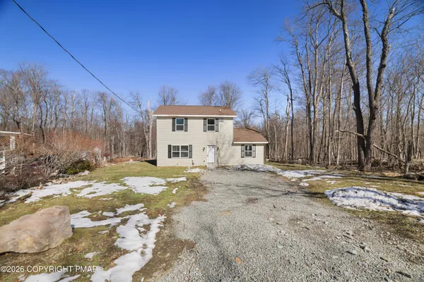 a view of a house with snow on the road