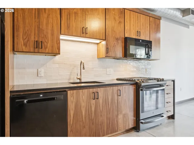 a kitchen with stainless steel appliances granite countertop a sink stove and microwave