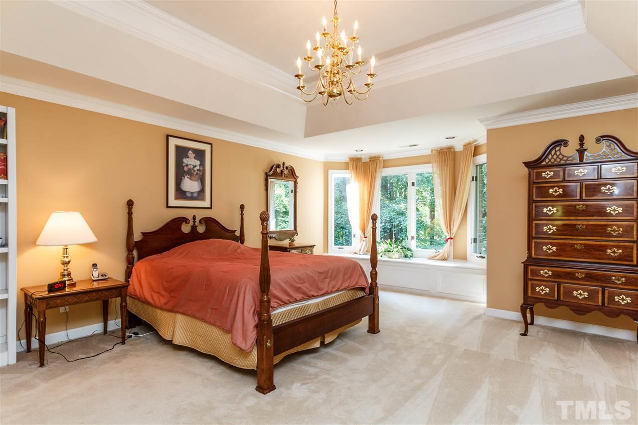 644 Pendleton Lake Road Raleigh, NC 27614 - Photo 19 of 25 a spacious bedroom with a bed and a chandelier