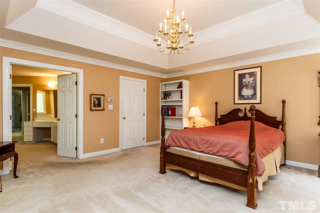 644 Pendleton Lake Road Raleigh, NC 27614 - Photo 20 of 25 a bedroom with a bed and a chandelier