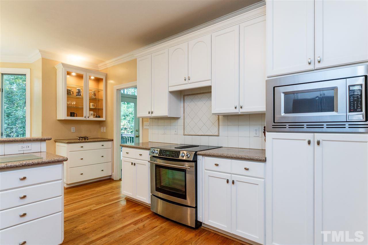 644 Pendleton Lake Road Raleigh, NC 27614 - Photo 8 of 25 a kitchen with white cabinets and stainless steel appliances