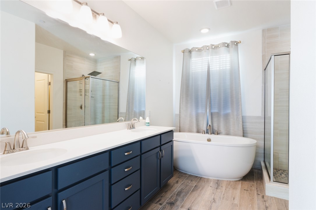 920 East Sunset Road Henderson, NV 89011 - Photo 15 of 33 Luxurious primary bath features a freestanding tub, separate shower, and double vanity with elegant cabinetry.