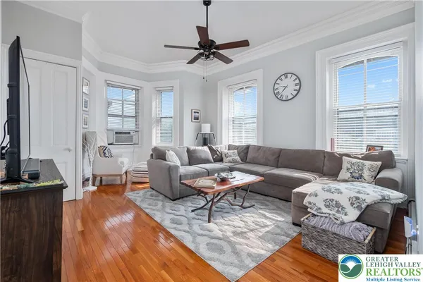 a living room with furniture a clock on wall and a window