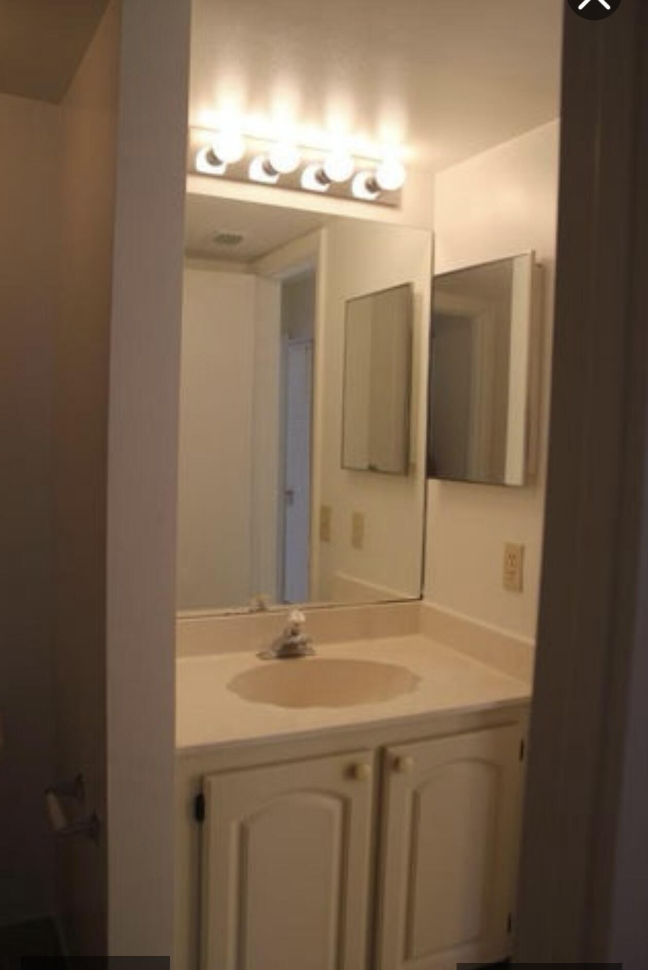 1256 South Military Trail, Unit 911 Deerfield Beach, FL 33442 - Photo 5 of 17 a bathroom with a sink and a mirror
