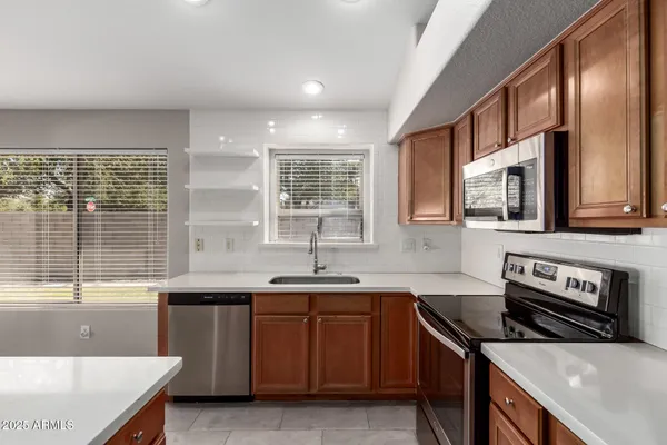 a kitchen with stainless steel appliances granite countertop a sink stove and cabinets