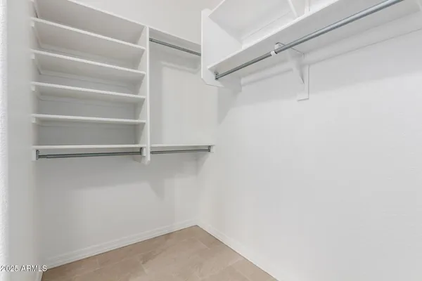 a view of walk in closet with empty racks