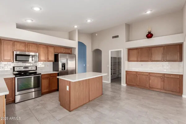 a kitchen with stainless steel appliances kitchen island granite countertop a stove and a sink