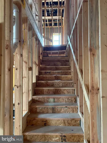 a view of staircase with wooden floor and white walls