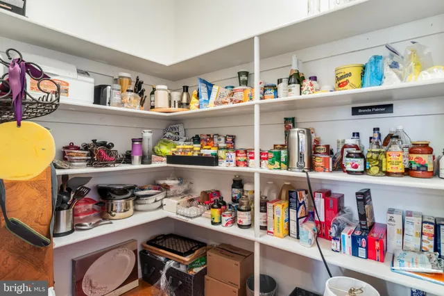 a view of a livingroom with a chandelier fan and wooden floor