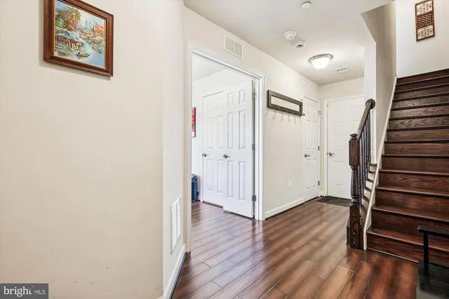 a view of a hallway with wooden floor and entryway