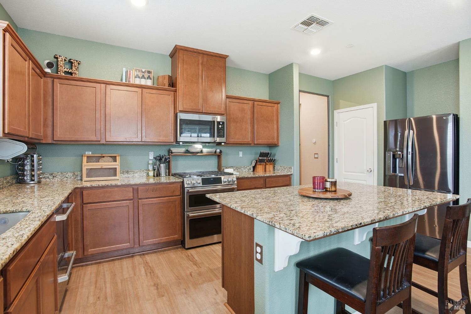 4640 Orchard Lane Rio Vista, CA 94571 - Photo 9 of 31 a kitchen with stainless steel appliances granite countertop a kitchen island a stove a sink a refrigerator a dining table and chairs