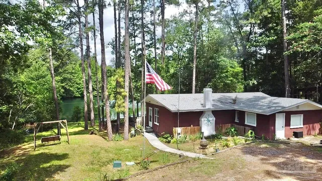a view of a house with backyard fountain and sitting area
