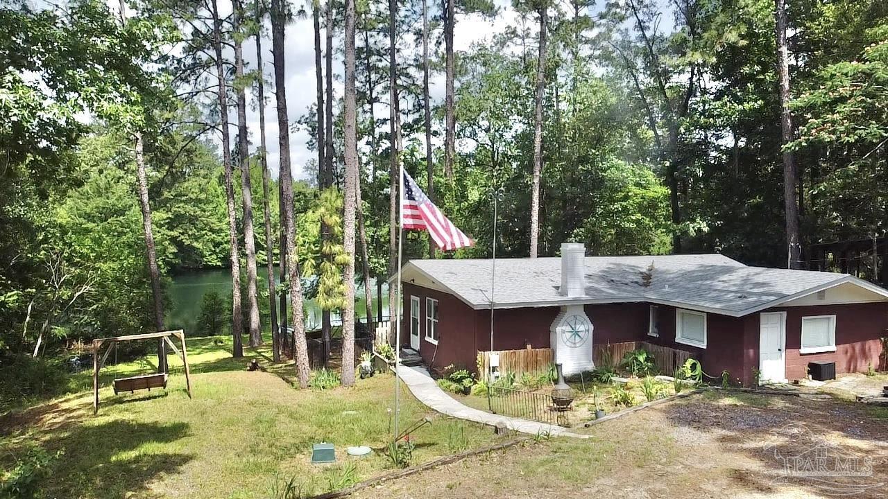 a view of a house with backyard fountain and sitting area