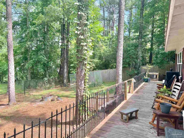 a view of deck with furniture and trees around