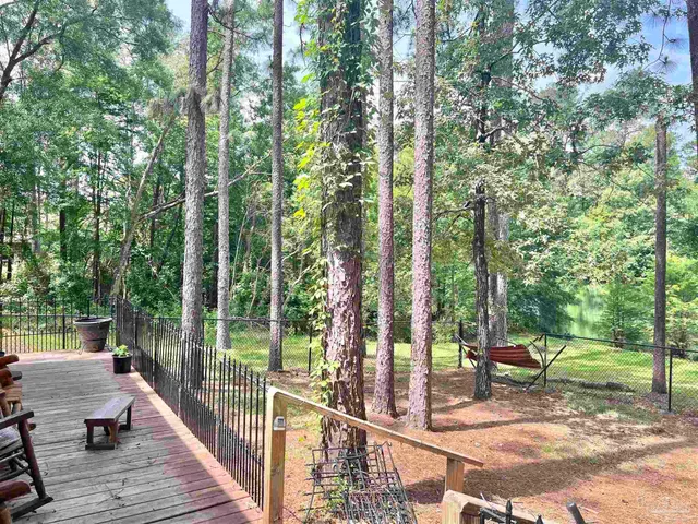 a view of a balcony with chairs and wooden fence