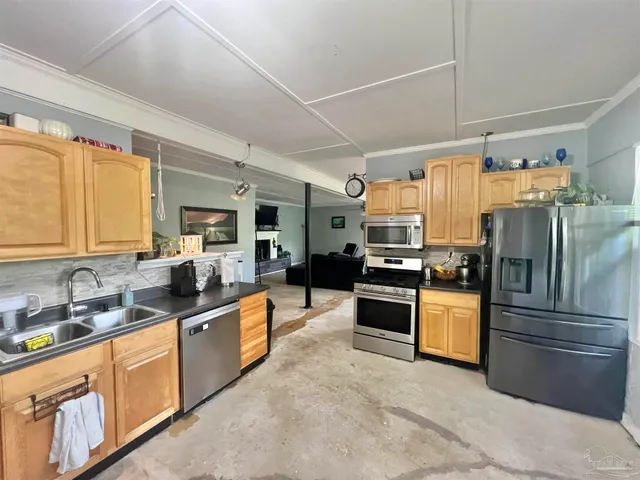 a kitchen with granite countertop a refrigerator and cabinets