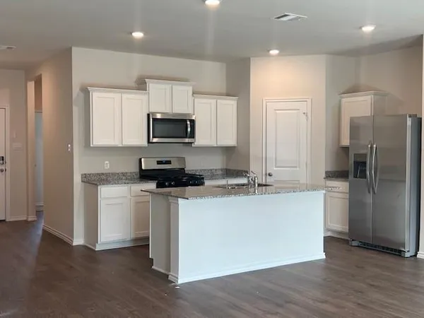 a kitchen with stainless steel appliances a refrigerator and a stove top oven