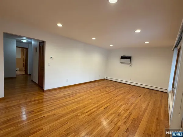 a view of empty room with wooden floor