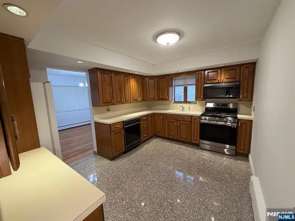 a kitchen with granite countertop a stove and a refrigerator