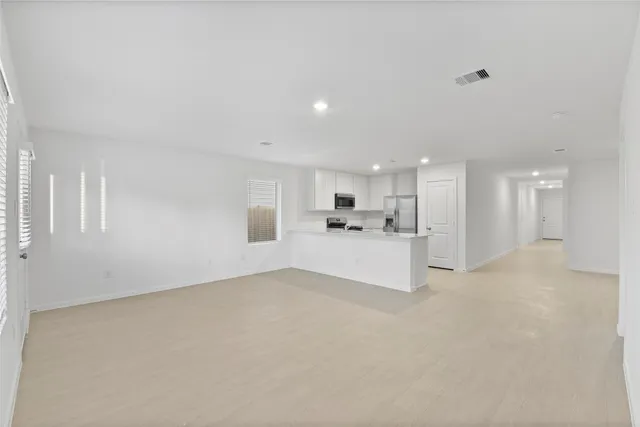 a view of kitchen and kitchen with white cabinets