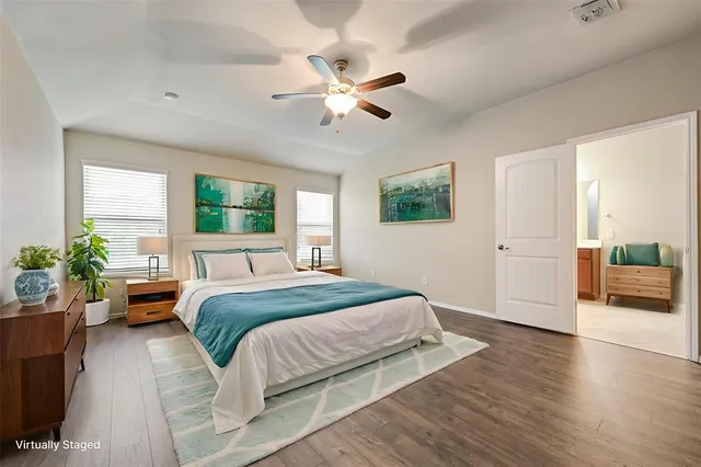 a spacious bedroom with a large bed and a chandelier